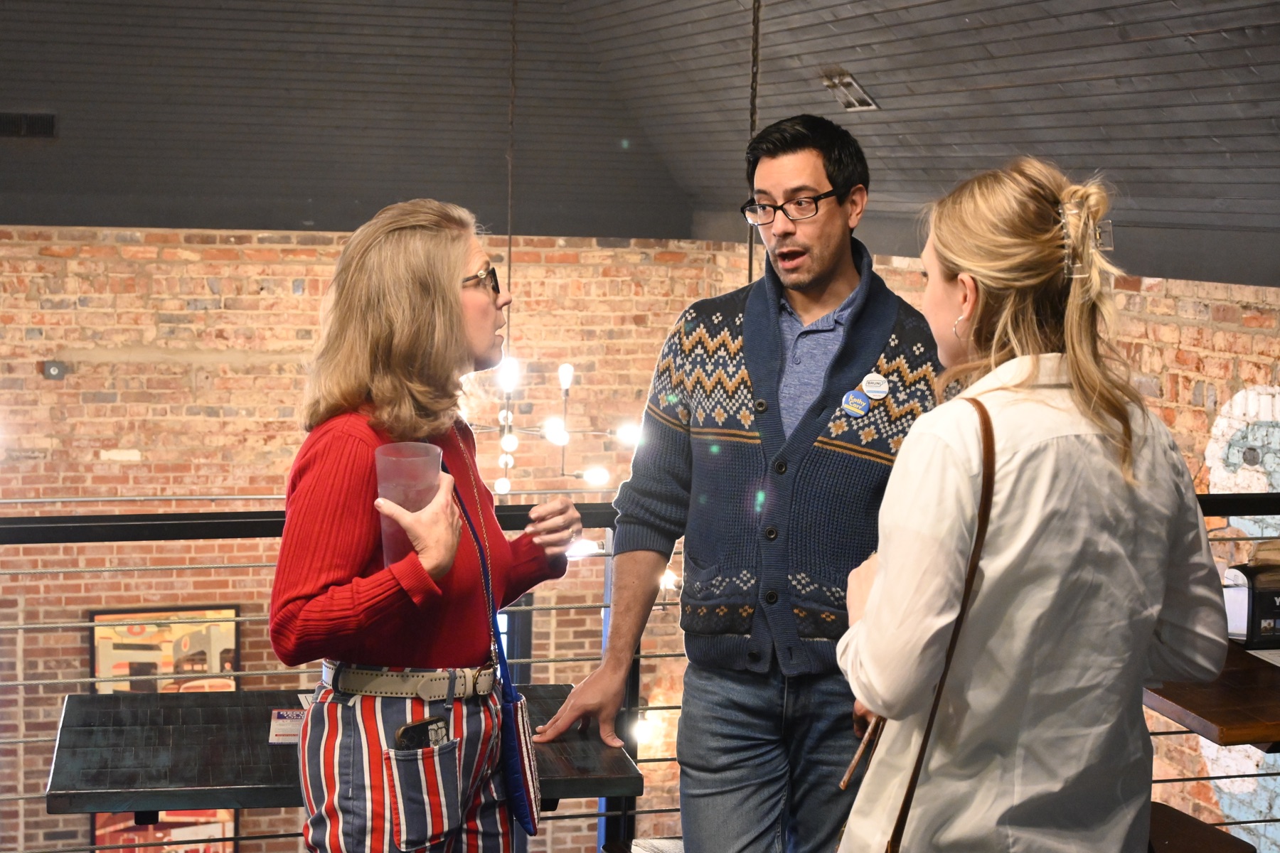 Three people talking together at a community gathering