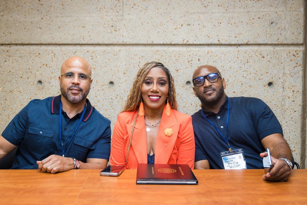 Three community leaders seated together on a summit panel