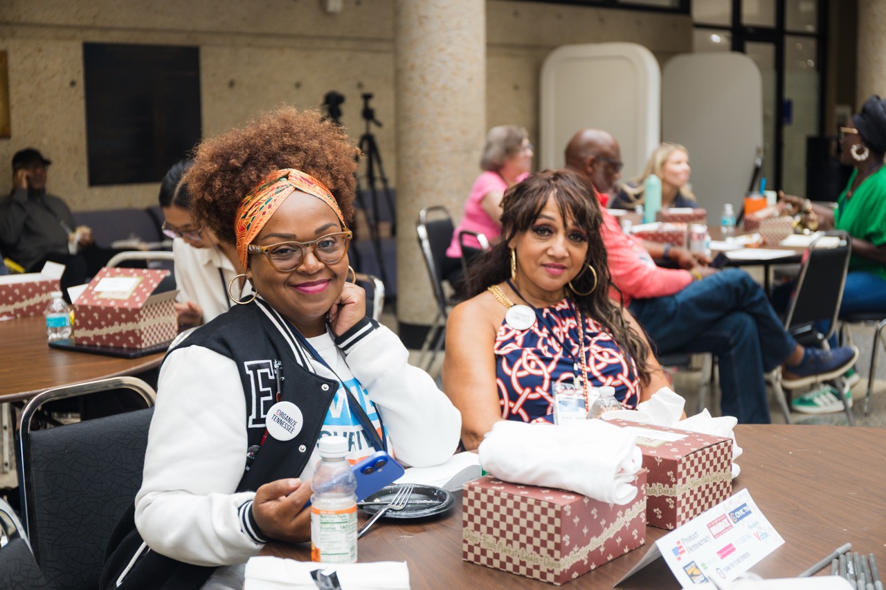 Community members gathered around workshop tables