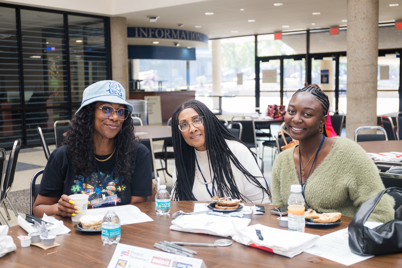 Three participants talking together at a workshop table